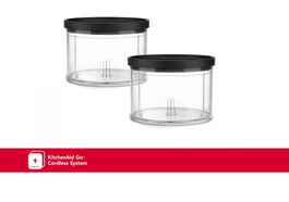 Two clear plastic chopper bowls with black lids, one larger than the other, with a KitchenAid logo in red on the bottom.